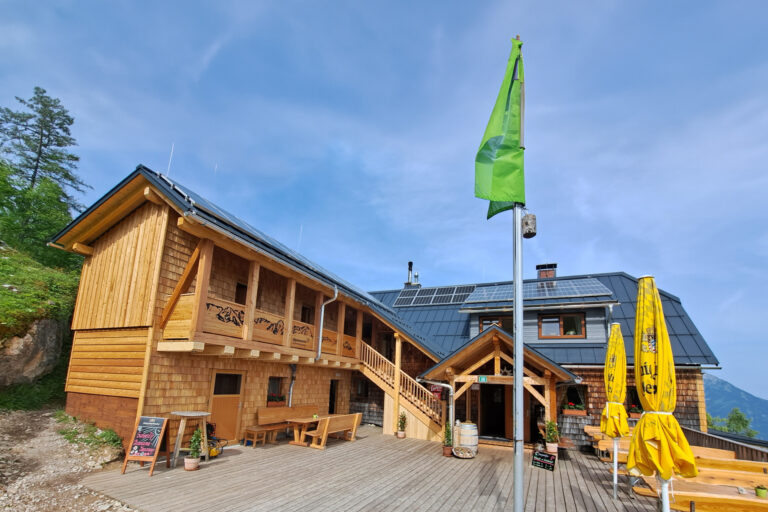 Foto einer Berghütte mit Terrasse.
